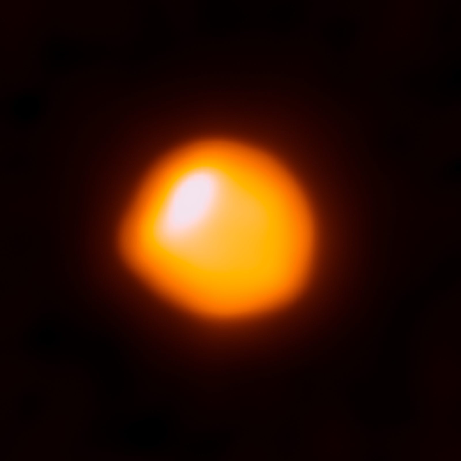 El disco anaranjado de una estrella gigante, con una zona más brillante desplazada hacia un lado del centro.