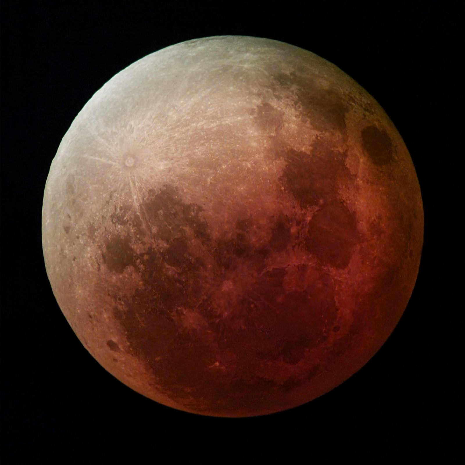 Primer plano de la Luna teñida por completo de un rojo cobrizo apagado, con los mares apenas insinuados.