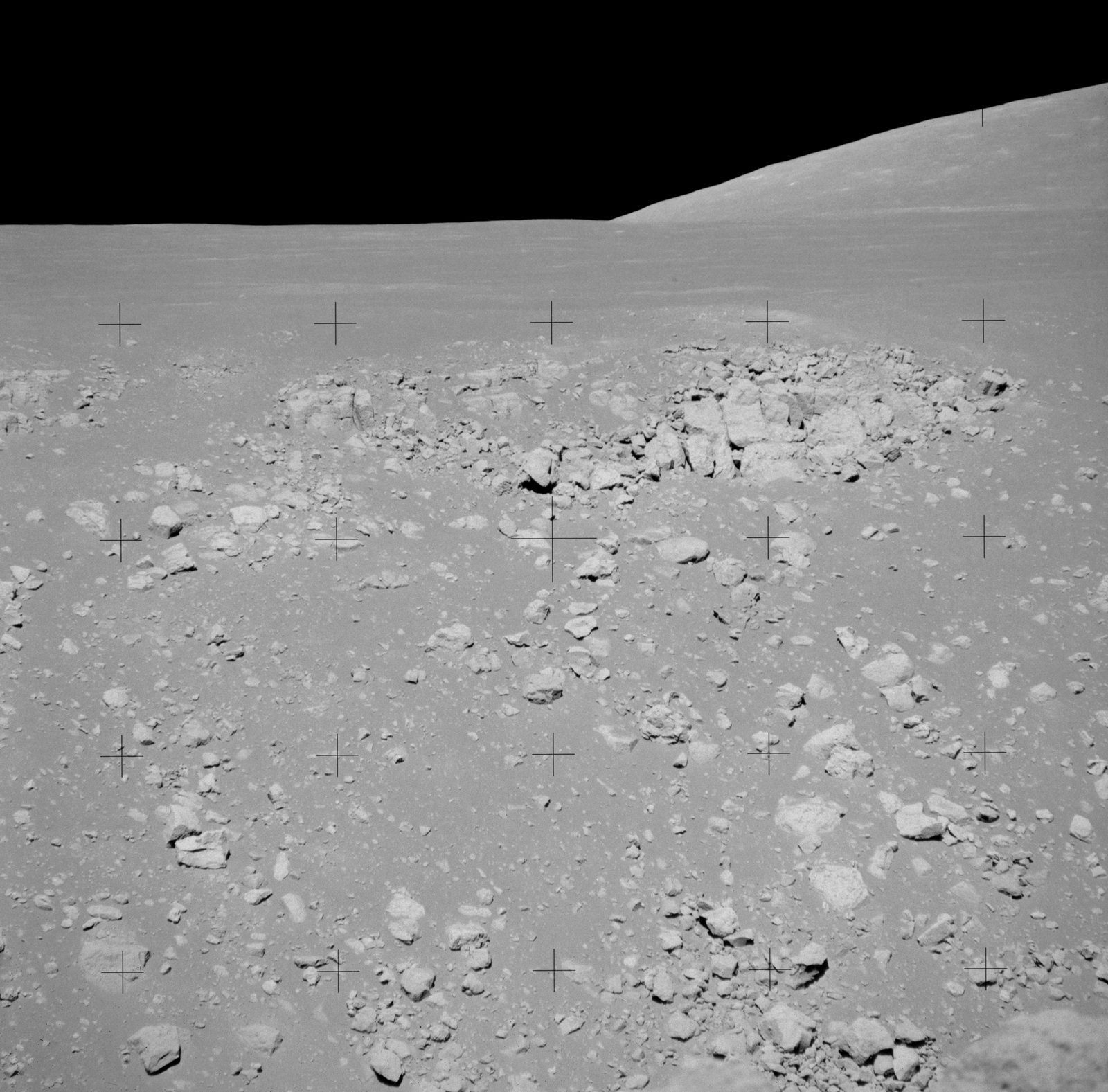 Terreno lunar gris y ondulado, sin una sola sombra de vegetación ni de aire, fotografiado con teleobjetivo.