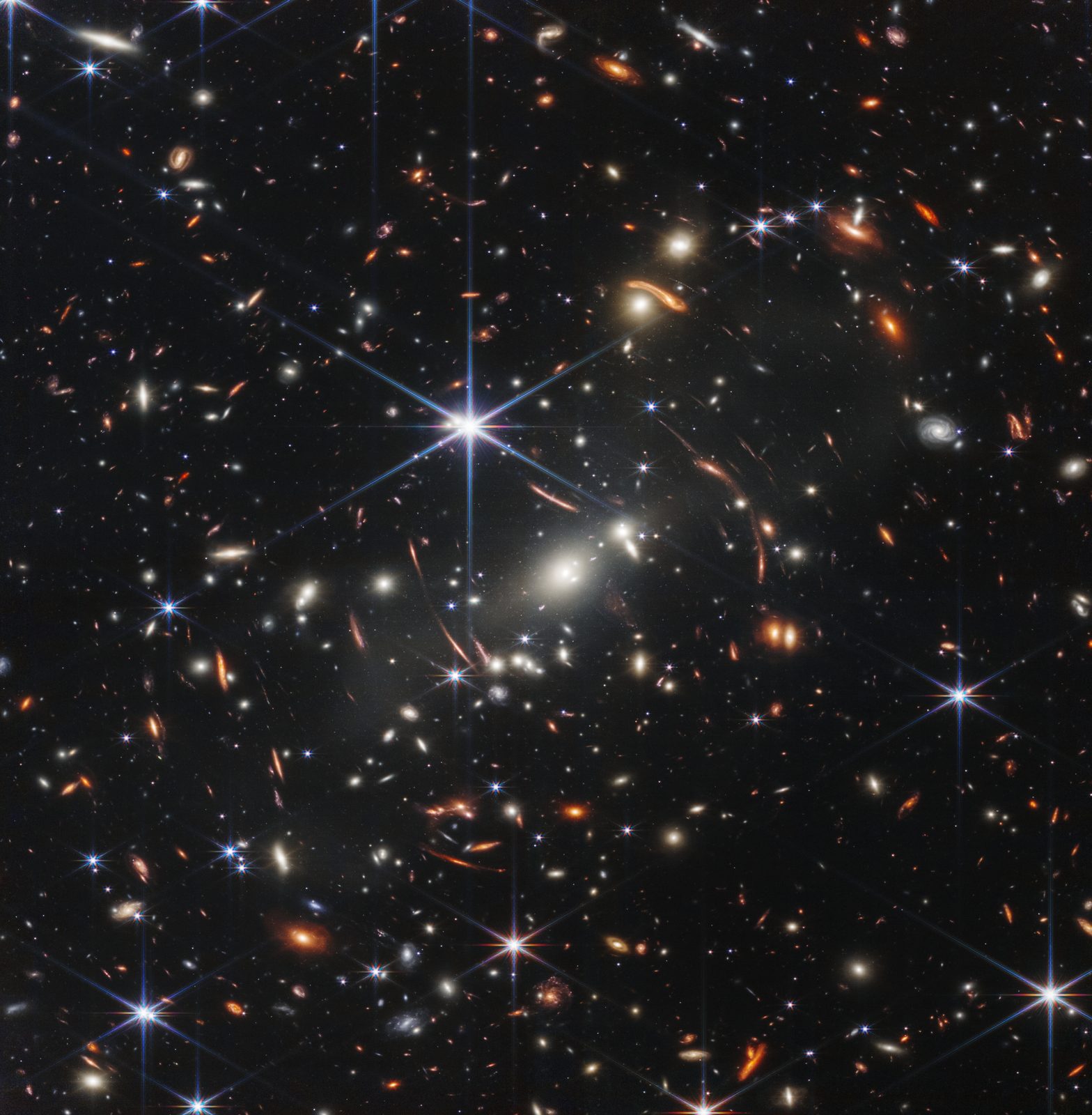 Un cuadro negro cuajado de galaxias blancas, doradas y rojizas, con varias estrellas de seis puntas y arcos anaranjados curvados alrededor del centro.
