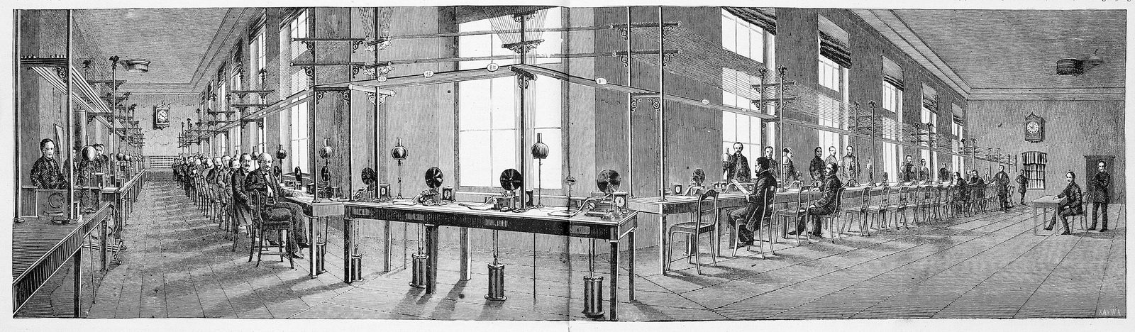 Grabado en blanco y negro del interior de una gran oficina de telégrafos, con dos hileras de mesas y operadores trabajando en sus aparatos bajo una nave acristalada.
