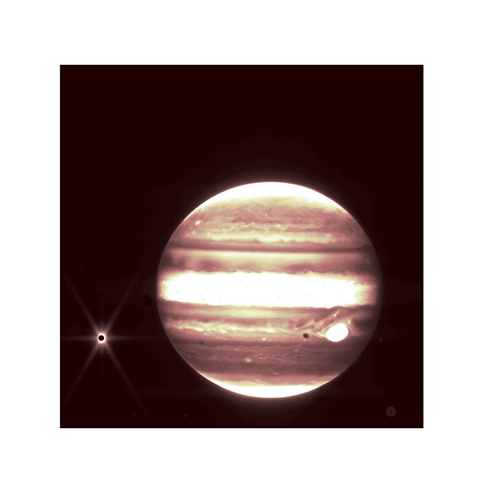 El disco de Júpiter en tonos rosados y crema, con sus bandas de nubes, y a la izquierda su luna Europa como un punto brillante con picos de difracción; la sombra de Europa se proyecta sobre el planeta.