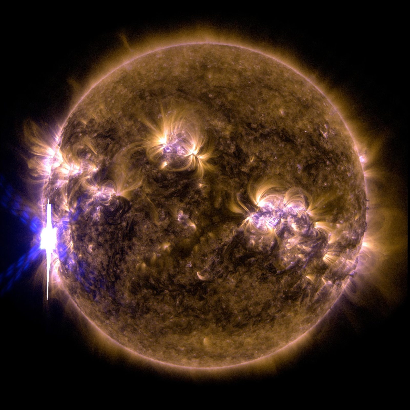 El disco del Sol en tonos anaranjados y dorados, con un estallido muy brillante en un borde.