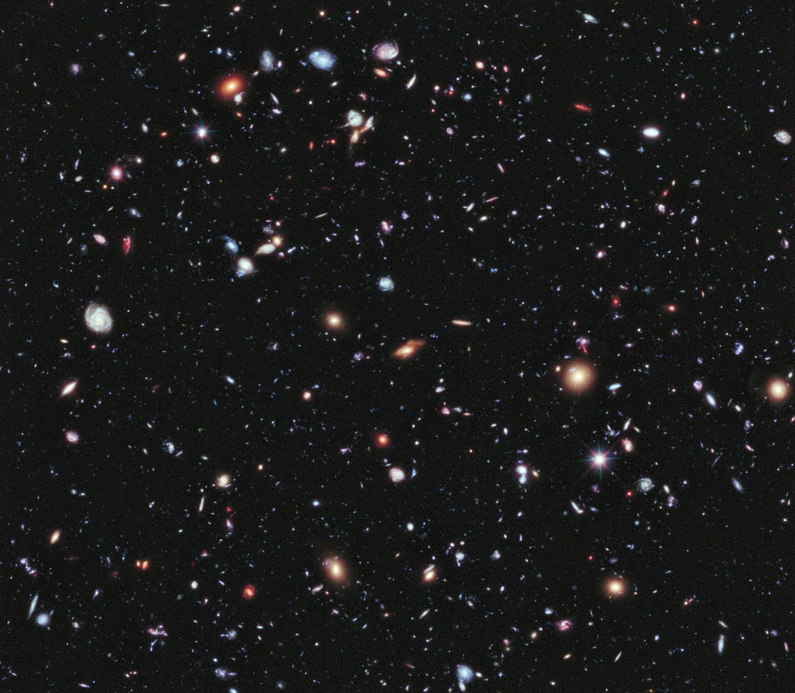 Un fondo negro sembrado de manchas de luz de todos los colores y formas, espirales, óvalos y puntos rojizos.