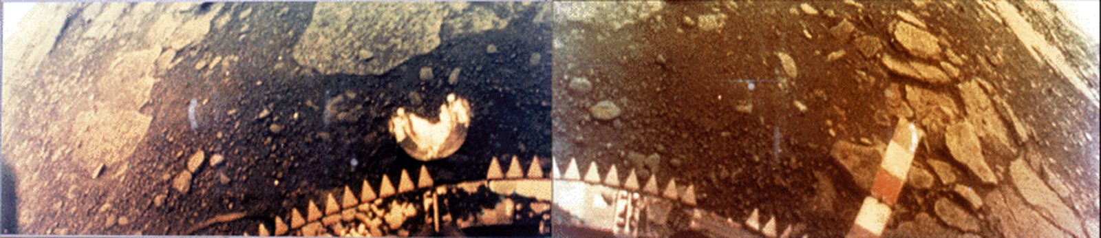 Panorama compuesto de dos fotogramas del suelo de Venus: la mitad izquierda en tonos grises azulados y la derecha anaranjada, con el borde dentado de la nave en primer plano.