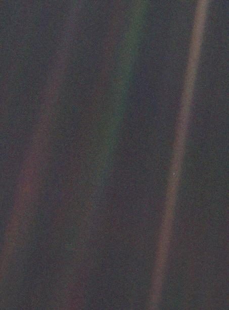 Una banda de luz difusa cruza una imagen granulada y oscura; dentro de ella hay un puntito claro y diminuto.