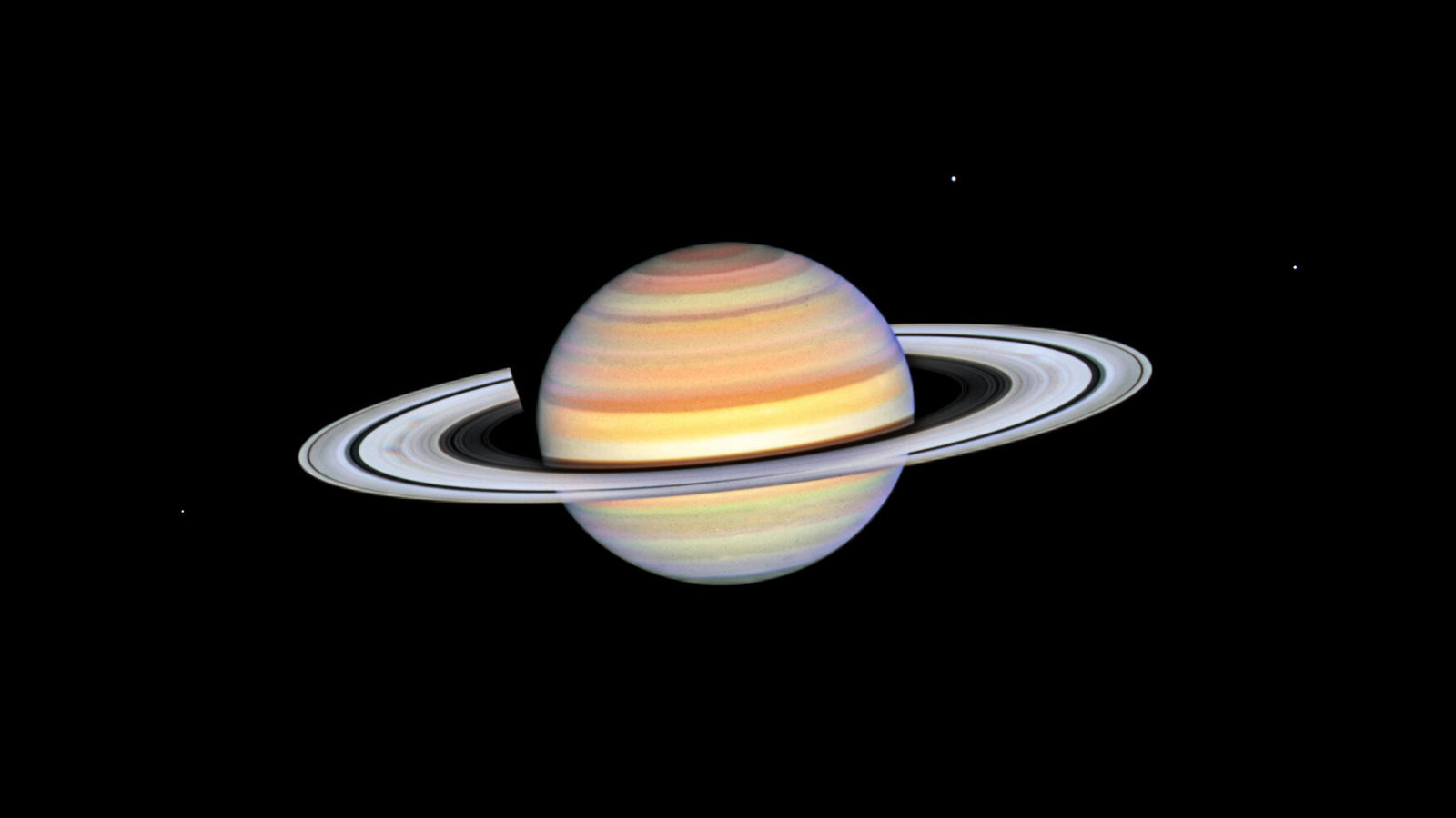Saturno fotografiado por el Hubble con los anillos poco inclinados y manchas oscuras radiales sobre el anillo B.