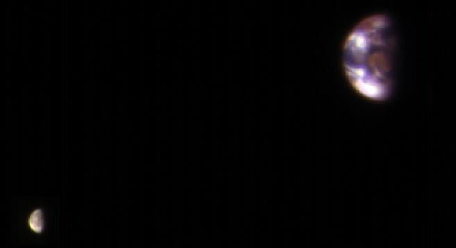 Sobre fondo negro, la Tierra como un disco pequeño con nubes y, a su lado, la Luna como un punto mucho más tenue.
