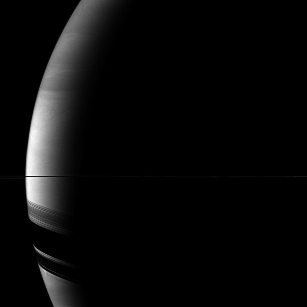 Saturno visto casi desde el plano de los anillos: los anillos se reducen a una línea fina que cruza el disco, y su sombra cae ancha sobre el hemisferio sur.